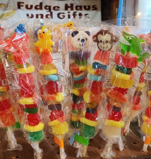 Gummy Fruit candies skewered on a stick , kabob style, topped with a gummy animal head