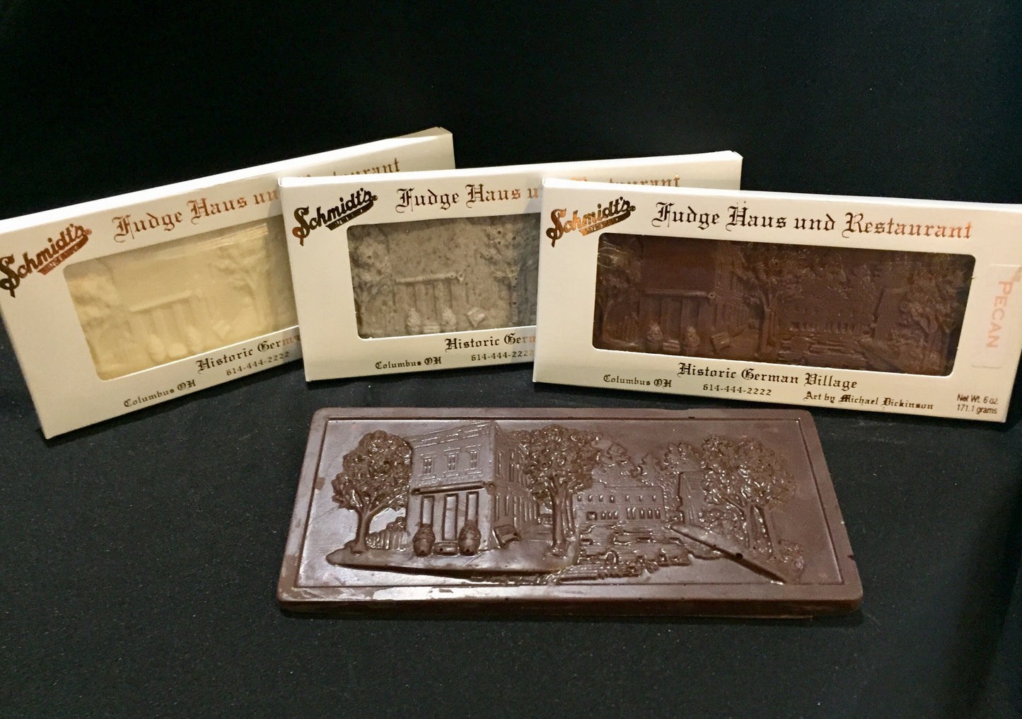 four flavors of chocolate bar, each depicting an embossing of Schmidt's Fudge Haus in German Village, Ohio,