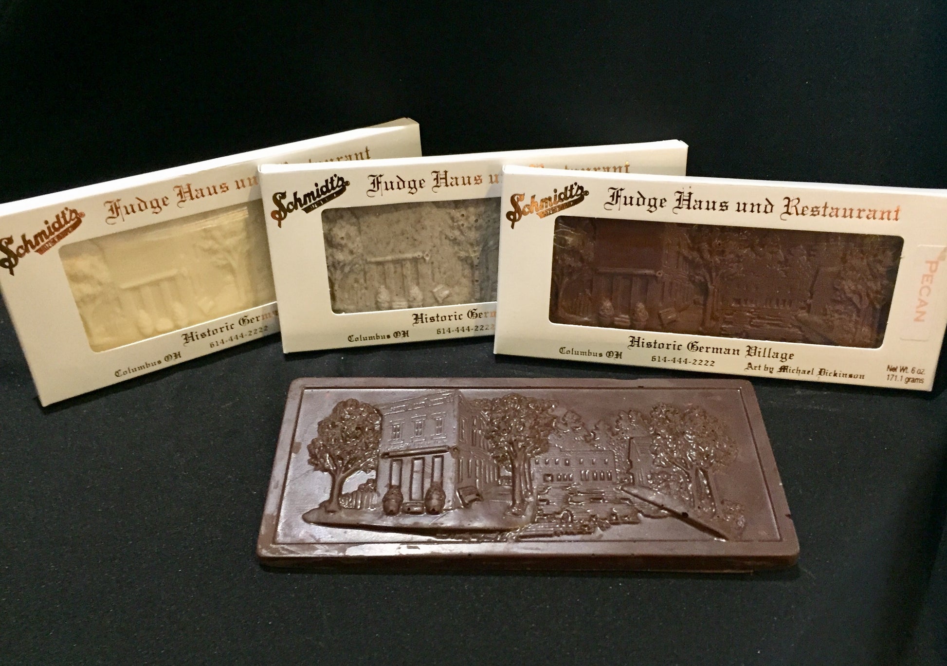 four flavors of chocolate bar, each depicting  an embossing of Schmidt's Fudge Haus in German Village, Ohio,